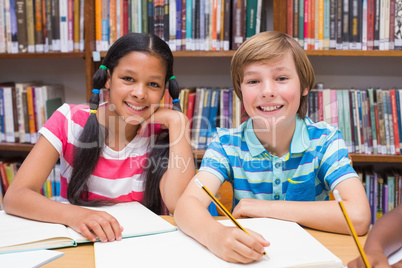 Cute pupils drawing in library