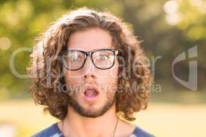 Handsome hipster looking surprised in park