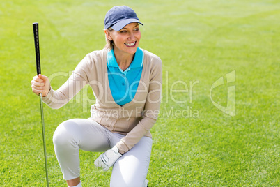 Female golfer kneeing on the putting green