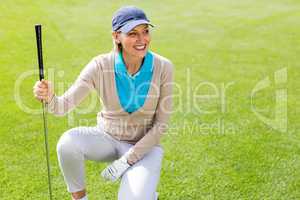 Female golfer kneeing on the putting green
