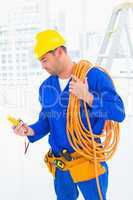 Electrician reading multimeter in bright office