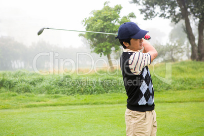 Golfer teeing off