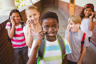 School kids using cellphones in school corridor