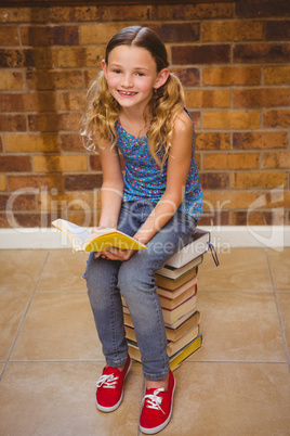 Cute little girl reading book in library