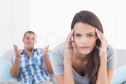 Woman suffering from headache while man arguing