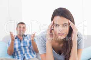 Woman suffering from headache while man arguing