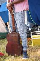 Hipster holding guitar at campsite
