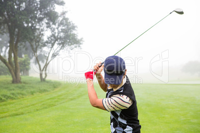 Golfer teeing off