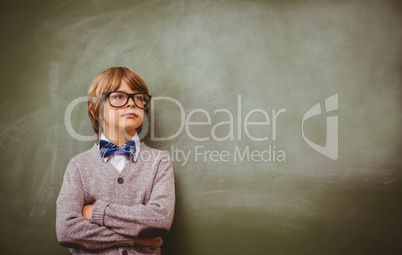 Boy with arms crossed looking up at blackboard