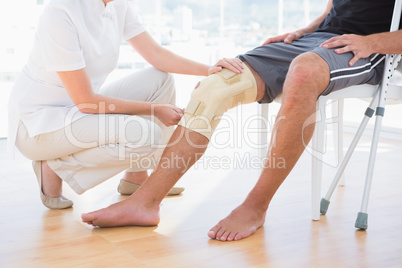 Doctor examining her patient knee