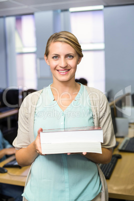 Female teacher holding books in computer class