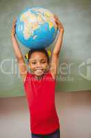 Little girl holding globe over head