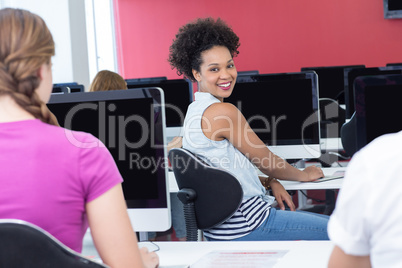 Student smiling at camera in computer class