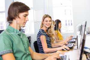 Student smiling at camera in computer class