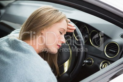 Tired woman asleep on steering wheel