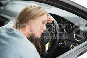 Tired woman asleep on steering wheel