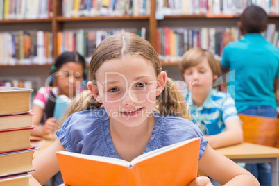 Cute pupils reading in library