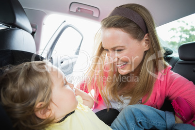 Happy mother playing with her daughter