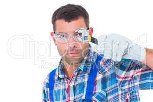 Confident repairman looking through wrench