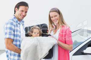 Parents carrying baby in his car seat