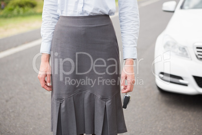 Elegant businesswoman standing in front of her car