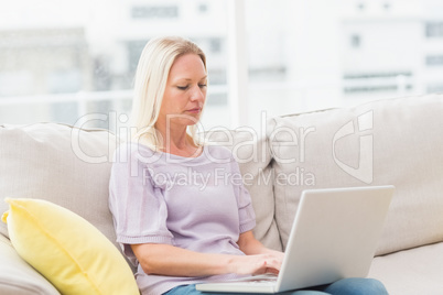 Woman using laptop white sitting on sofa