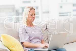Woman using laptop white sitting on sofa