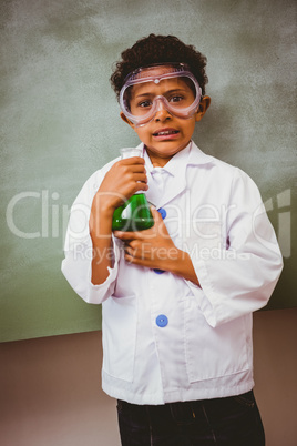 Boy holding conical flask in classroom