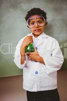 Boy holding conical flask in classroom