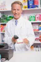 Pharmacist using machine and holding medicine