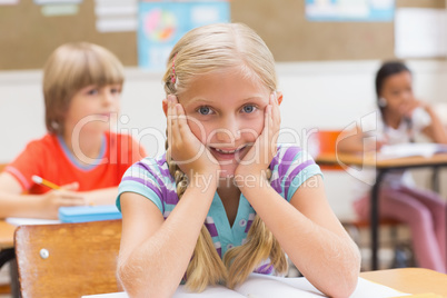 Smiling pupil sitting at her desk