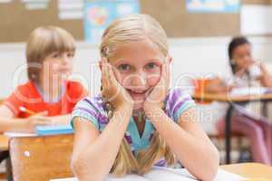 Smiling pupil sitting at her desk