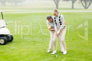 Golfing couple putting ball together