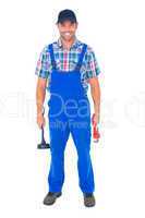 Male plumber holding plunger and wrench