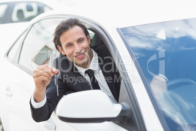Businessman smiling and showing key