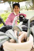 Happy golfer driving his golf buggy smiling at camera