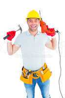 Smiling handyman holding hammer and drill machine