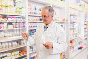 Senior pharmacist looking at medicine and prescription