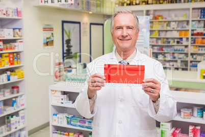 Smiling senior pharmacist holding envelope