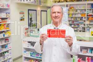 Smiling senior pharmacist holding envelope