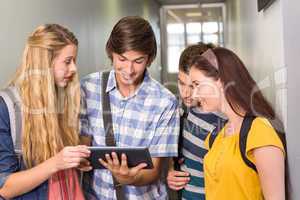 Students using digital tablet at college corridor