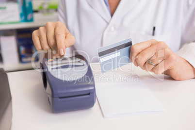 Pharmacist using keypad and holding credit card