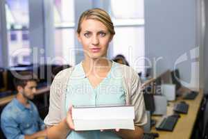 Female teacher holding books in computer class