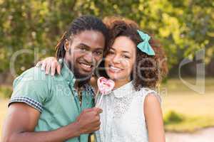 Cute couple in the park sharing a lollipop