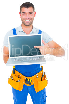 Happy repairman pointing at laptop