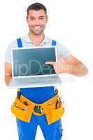 Happy repairman pointing at laptop