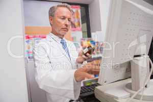 Senior pharmacist using the computer