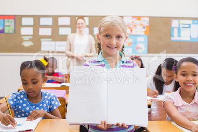 Cute pupil smiling at camera during class presentation