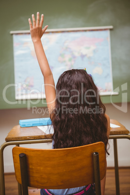 Little girl raising hand in classroom