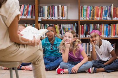 Cute pupils and teacher having class in library